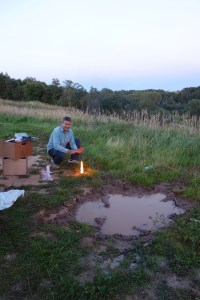 Classy scene. Luke warms his hands by our mud puddle.