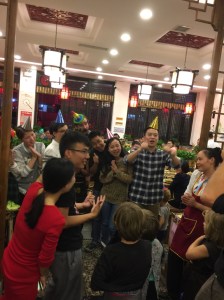 Jens and Bully (in red) help direct a crowd of strangers to sing happy birthday (in Chinese) in a video to Arne's Dad. 